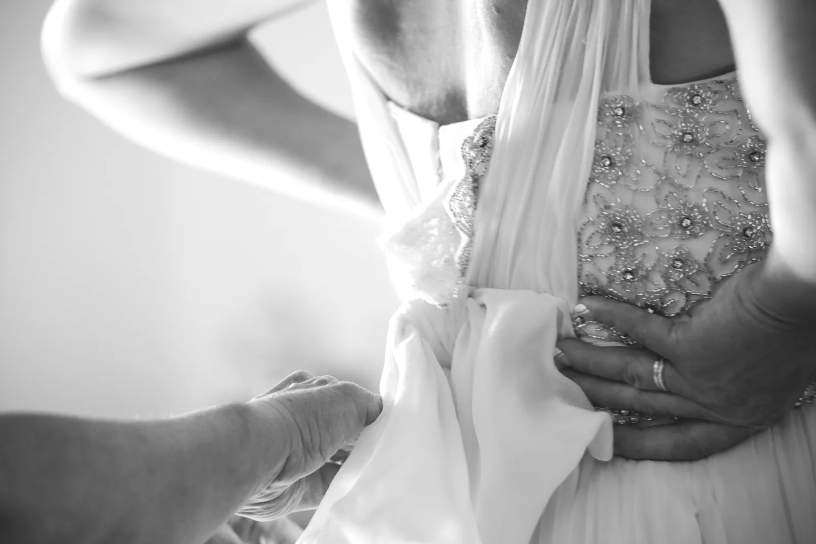 Detalle en blanco y negro de los preparativos del vestido de novia