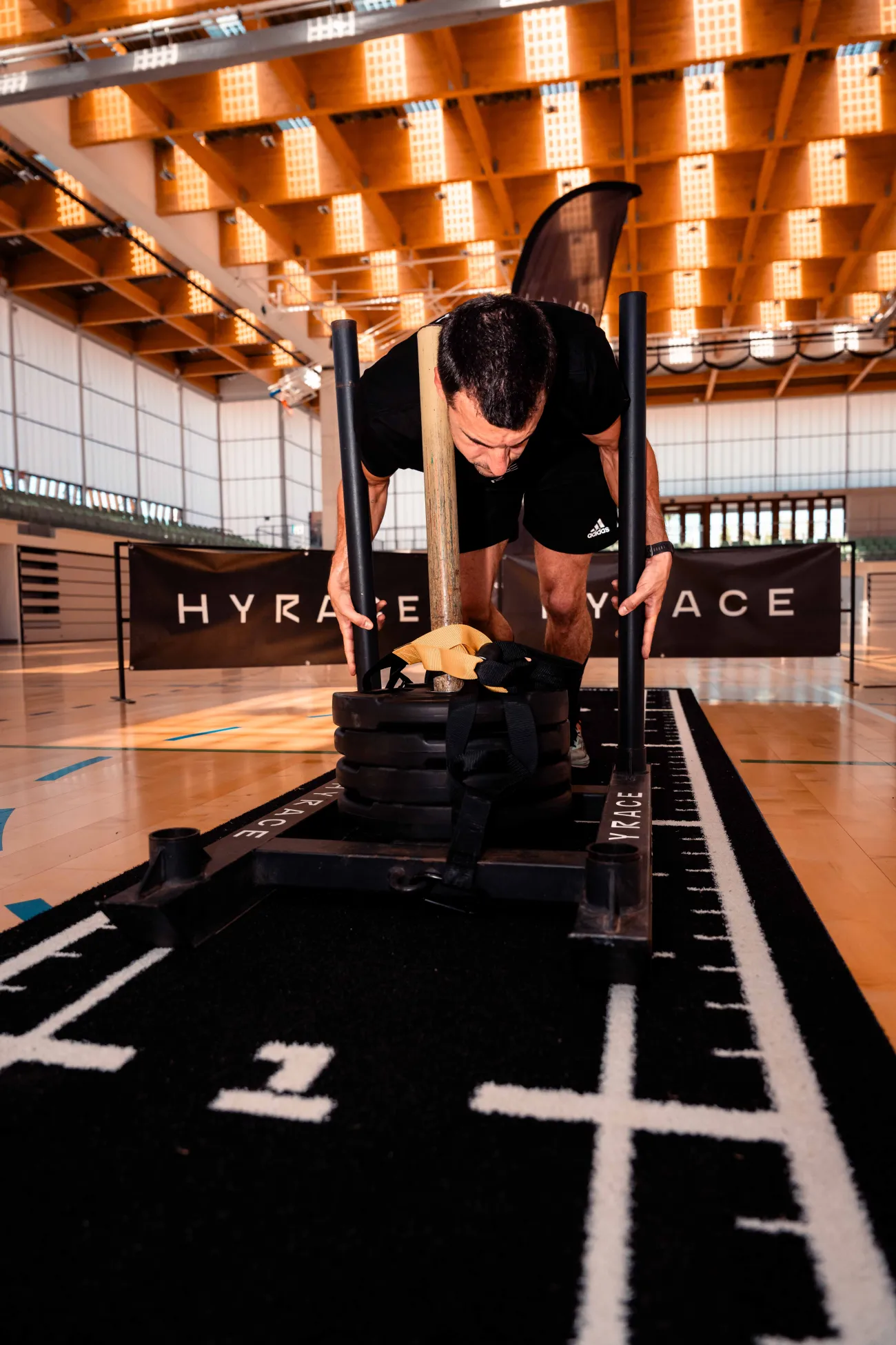 Atleta preparando el empuje de trineo en una pista HYROX